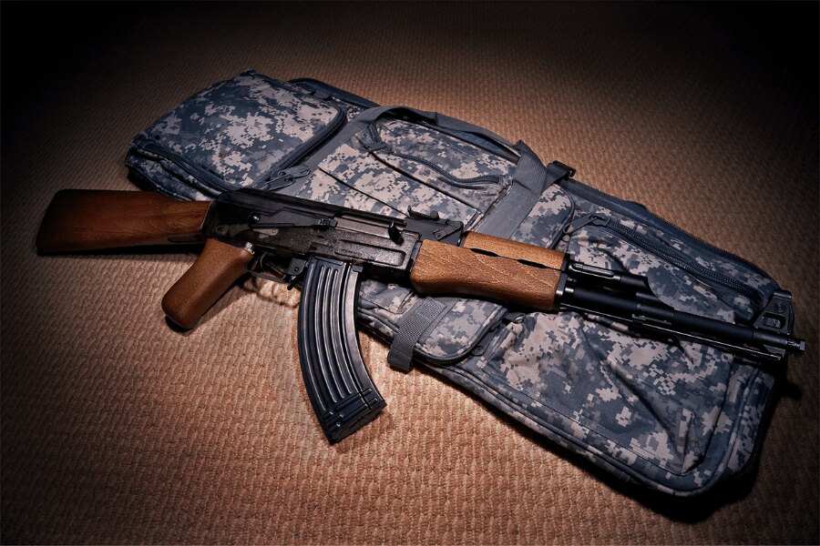 G&G Armament airsoft replica of an AK-47 resting on a padded rifle case.