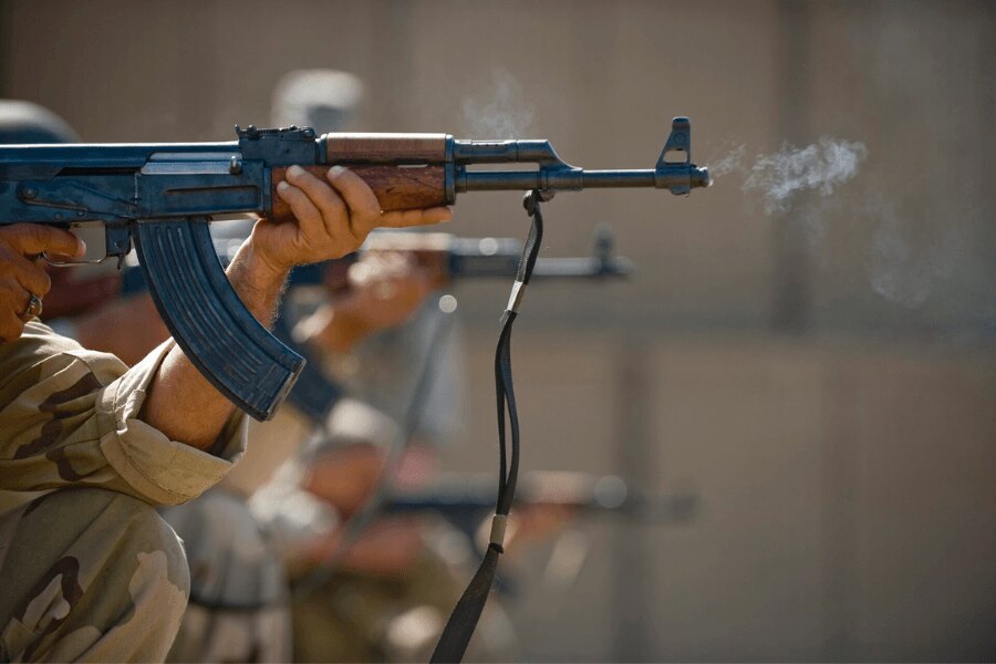Iraqi Air Force airman firing an AK-47 during training at a shooting range.
