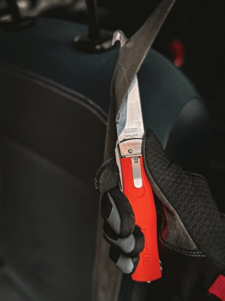 Mikov rescue knife cutting a seat belt inside a vehicle.