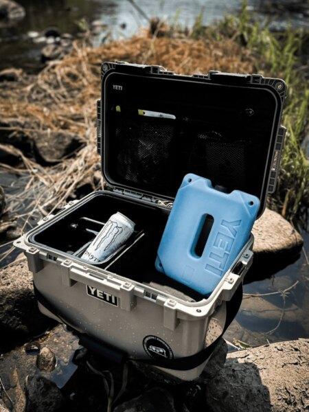 An open YETI LoadOut GoBox containing an ice pack and a canned drink.