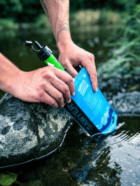 Filtering water through a Sawyer filter attached to a collapsible water pouch.