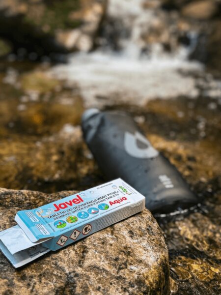 Javel Aqua water purification tablets beside a mountain stream.