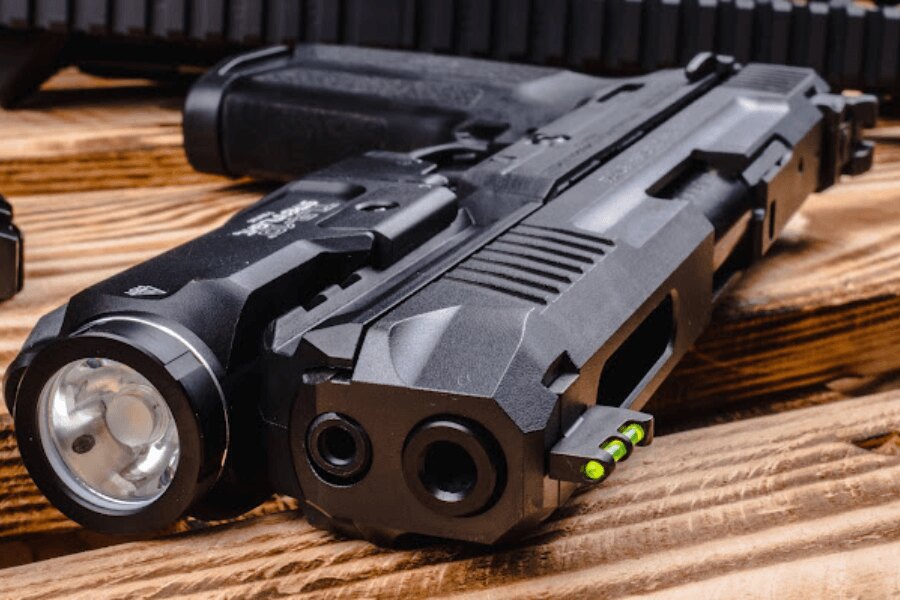 Close-up of the green fiber-optic insert in the front sight of a Ruger-57 pistol equipped with a weapon light.