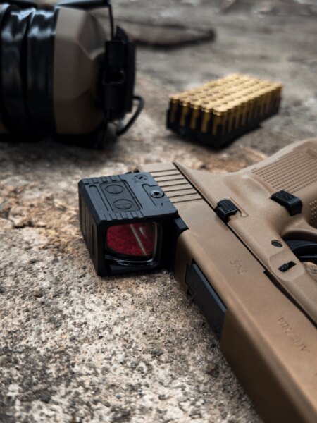 Detail of a closed Holosun collimator mounted on a Glock 19X pistol.