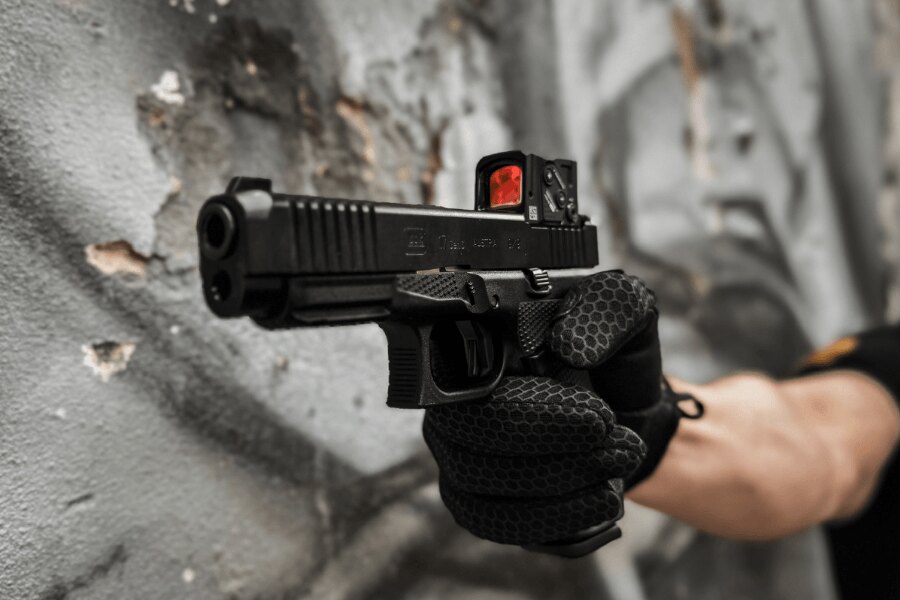 Aiming a Glock 17 fitted with a red dot sight.