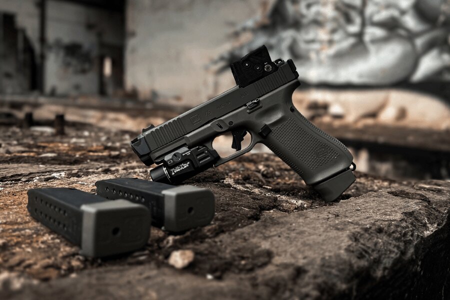 Glock 45 with a red dot sight, weapon light, and two magazines.