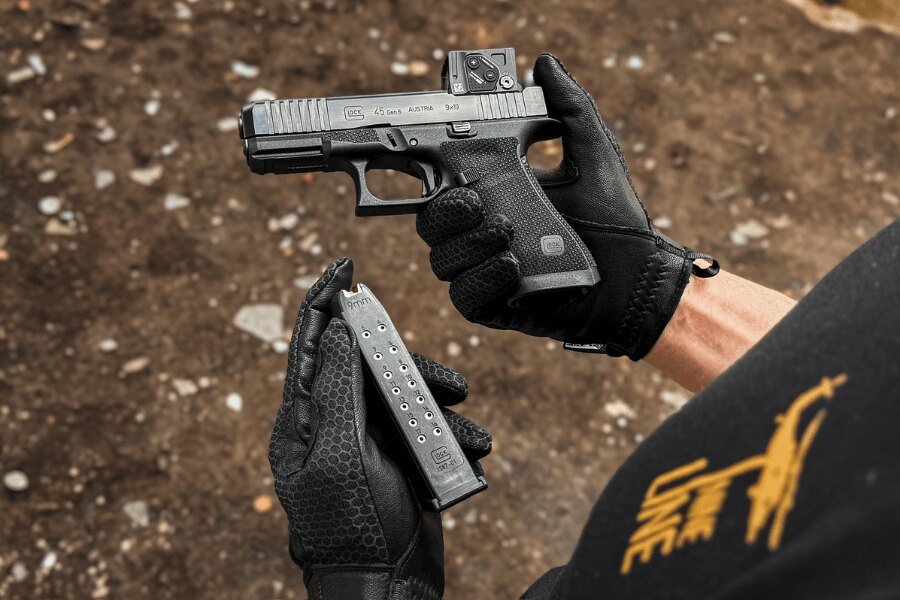 Reload drill with a Glock 45 fitted with a red dot sight and a spare magazine.