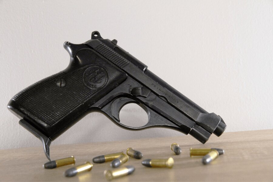 Side view of a Beretta 71 pistol with .22 LR cartridges.