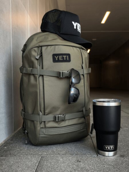 Light grey YETI Ranchero 27L backpack with a cap and a black YETI Rambler bottle.