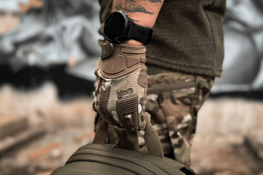 Close-up of a MoG Frog 1.5 tactical glove cuff beneath a wristwatch while carrying a bag.