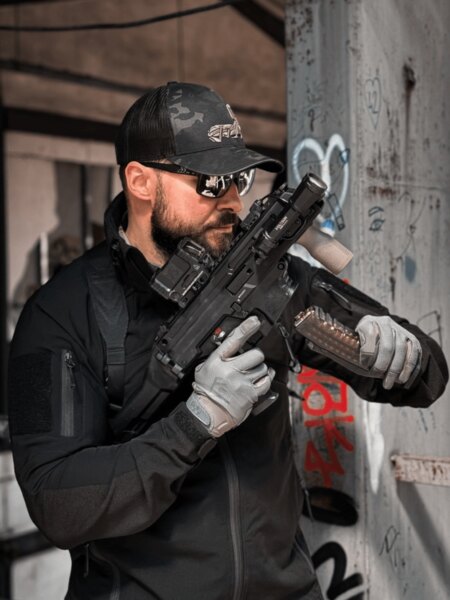 Gloved shooter handling the translucent magazine of an HS Produkt KUNA.